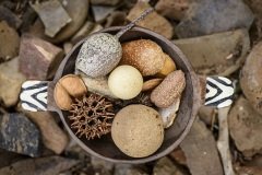 Ethnic earth arrangement of wooden bowl with natural objects.