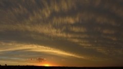 Fluffy cloud details above the setting sun.